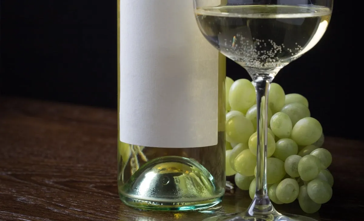 a wine bottle, grapes, and a glass of wine