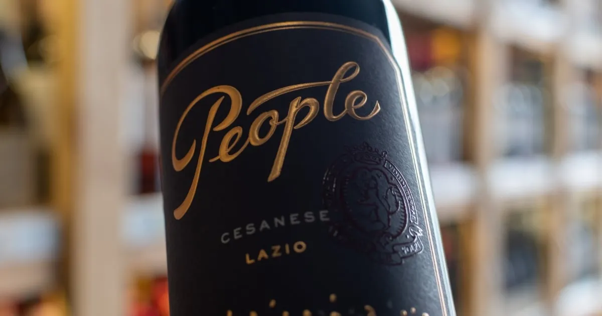 Close-up of a wine label with gold foil script and an embossed crest